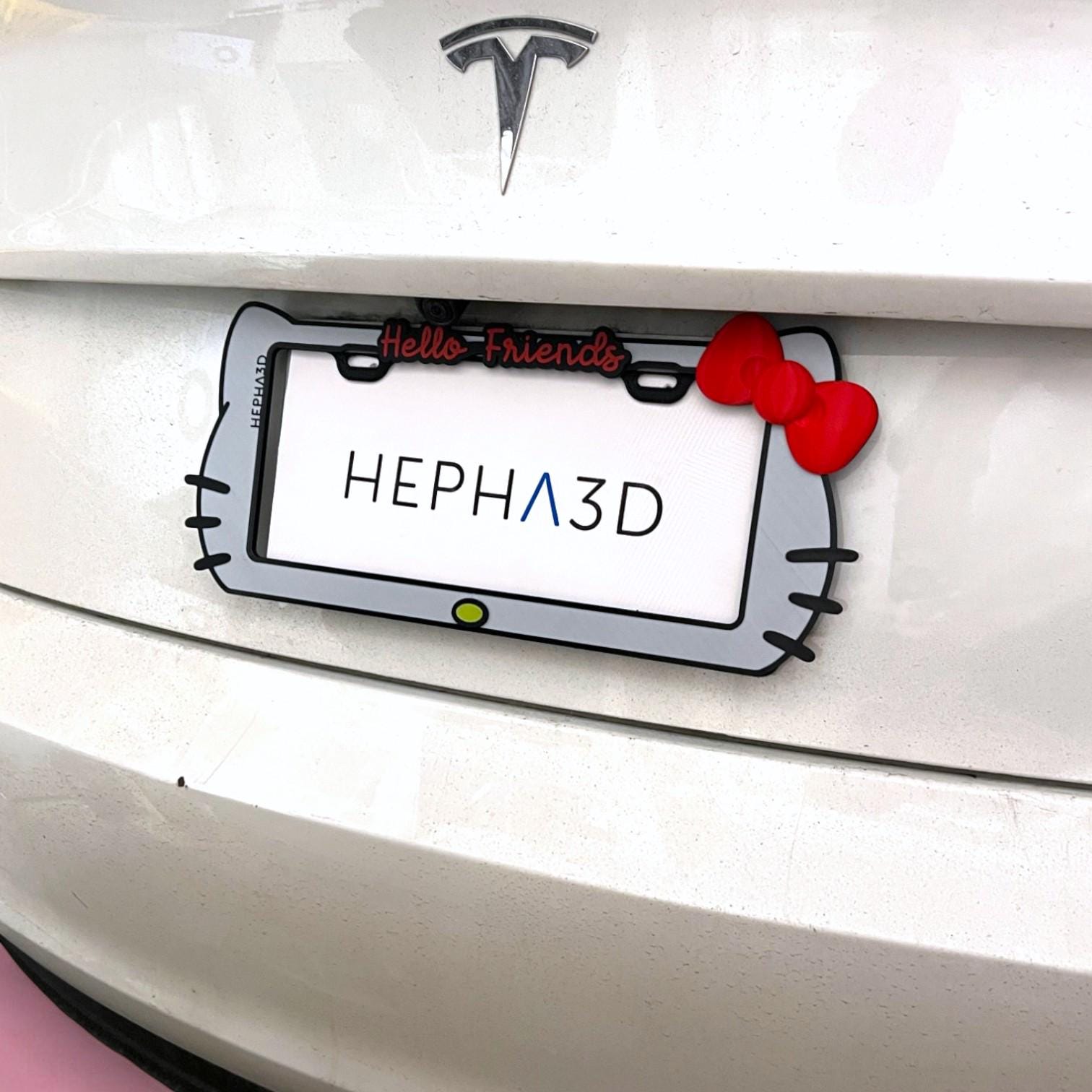 Hello Kitty x PopPlates — 3D printed kawaii license plate frame with bow and cat ear details, available in red and pink, made in Vancouver BC