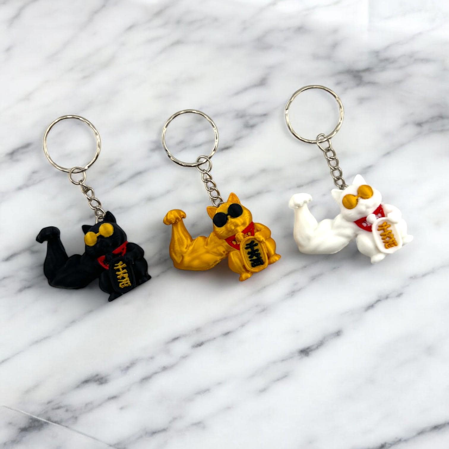 Super Buff Maneki Neko Keychain — 3D printed muscular lucky cat charm in gold, white, and black, made in Vancouver BC Main image