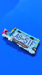 Kirby x PopPlates — oversized 3D printed license plate frame with Kirby in mid-inhale pose on a floating cloud platform, made in Vancouver BC