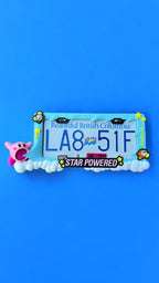 Kirby x PopPlates — oversized 3D printed license plate frame with Kirby in mid-inhale pose on a floating cloud platform, made in Vancouver BC